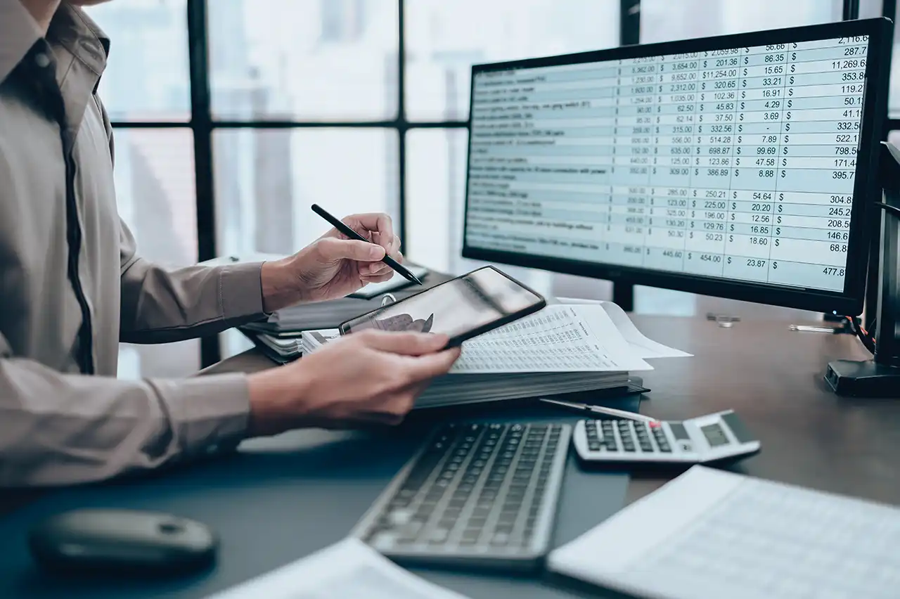 Analyst reviewing billed line items and charges on a monitor with invoice data