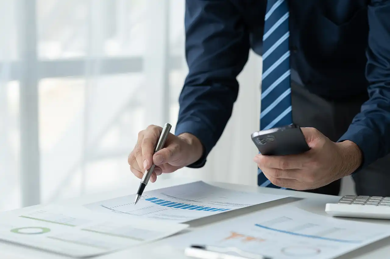 Finance professional checking utility cost reports and calculating billing changes